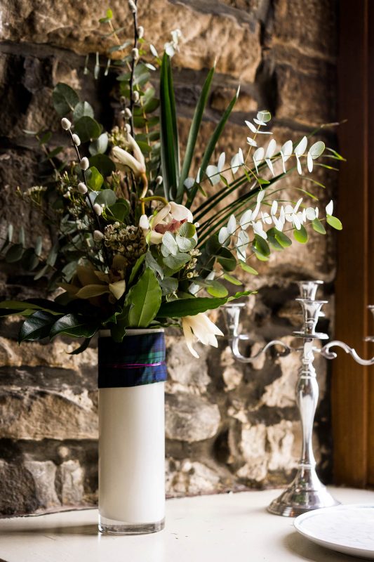 Vase of flowers next to silver candle holder